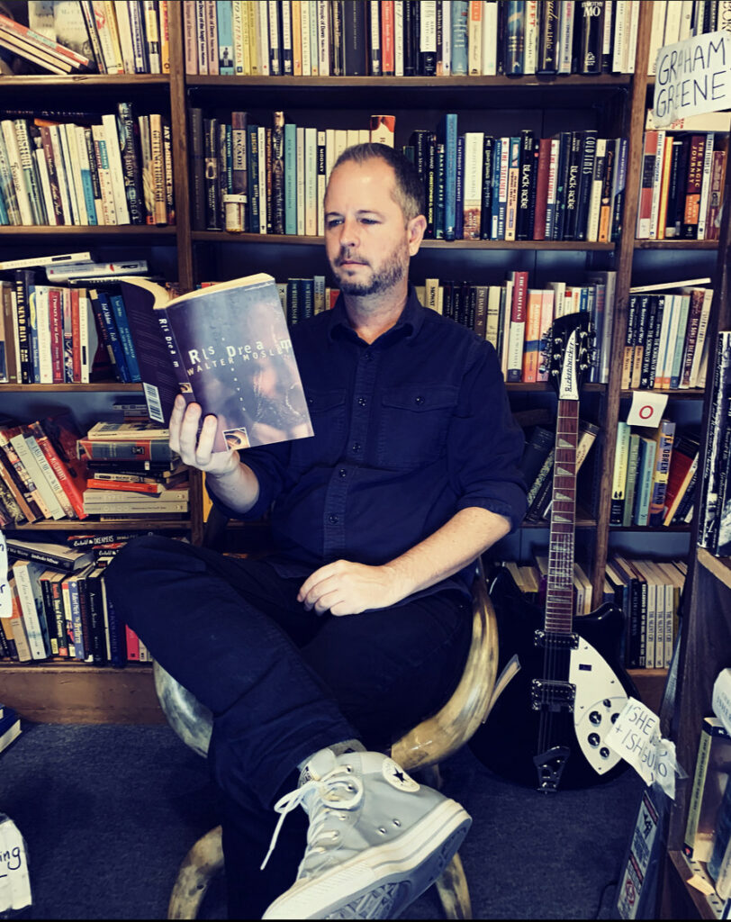 Kyle Burke of Capitol Hill Books reads inside his shop; speaks on National Book Lovers Day