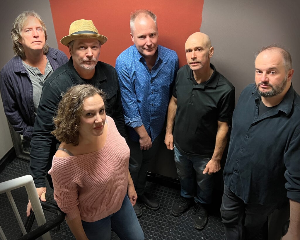 Electric Light Orchestra (ELO) tribute band Atomic Light Orchestra (ALO) pose for a group photo in a stairwell.