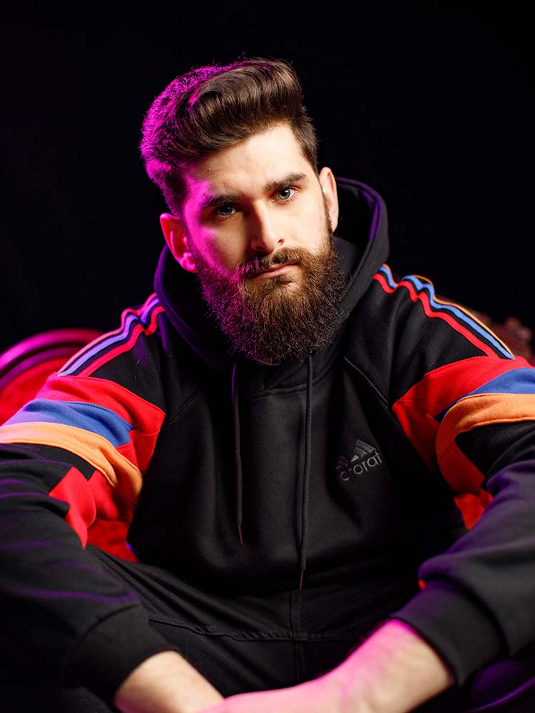 Marc 2Ray looks directly at the camera wearing a black sport jacket.