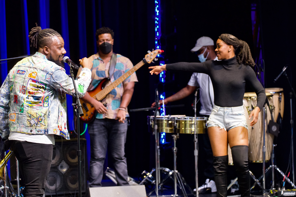 The Experience Band and Show performing on stage together.