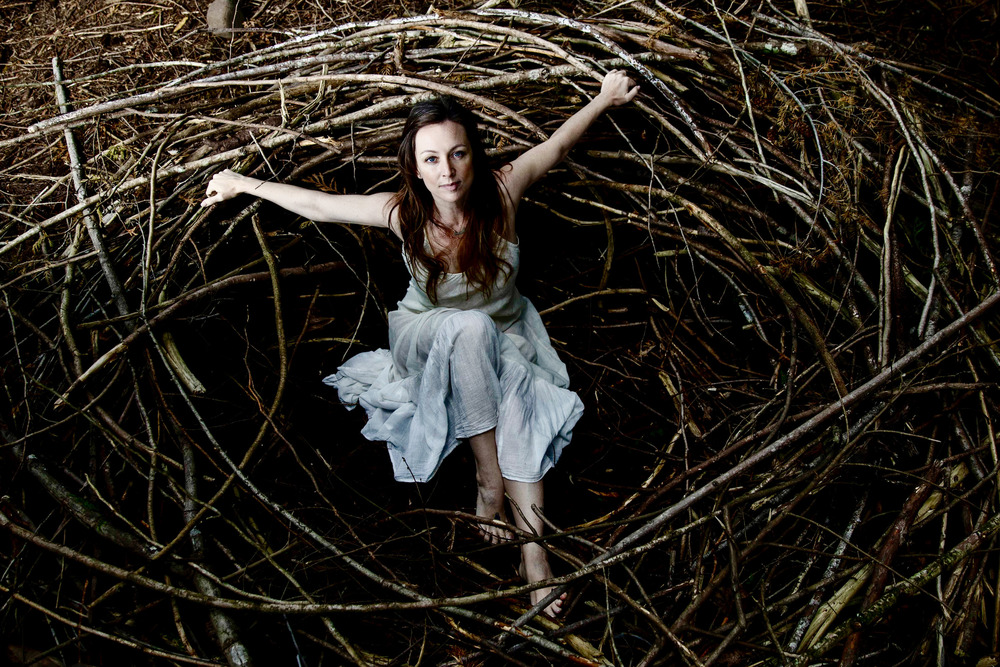 Tara MacLean laying in a large nest.