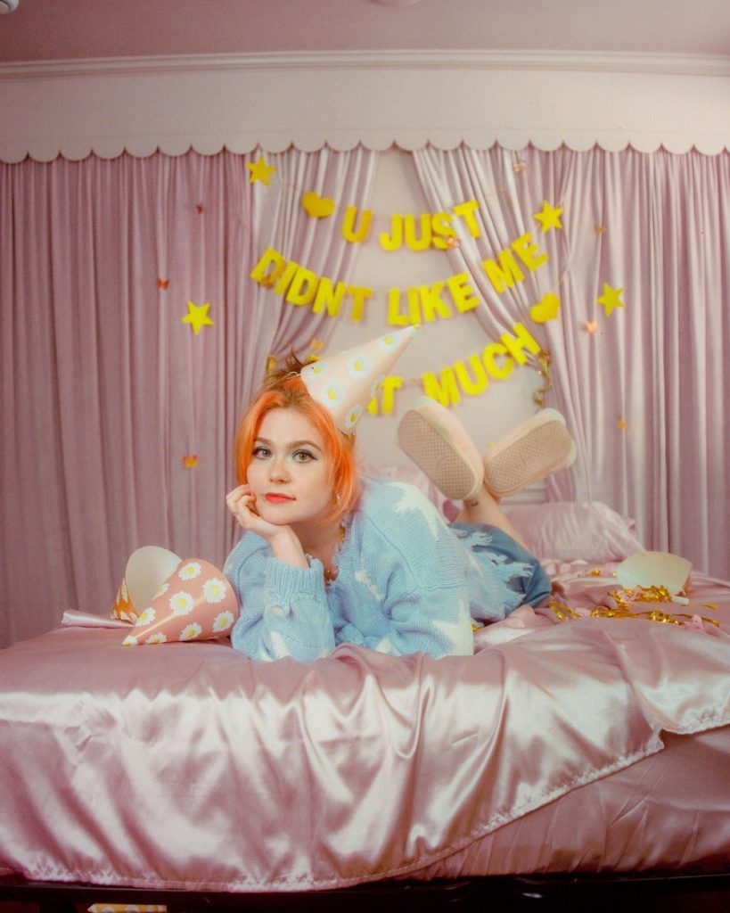 Leanna Firestone EP promotional photo, sleepover with "You Just Didn't Like Me That Much" banner