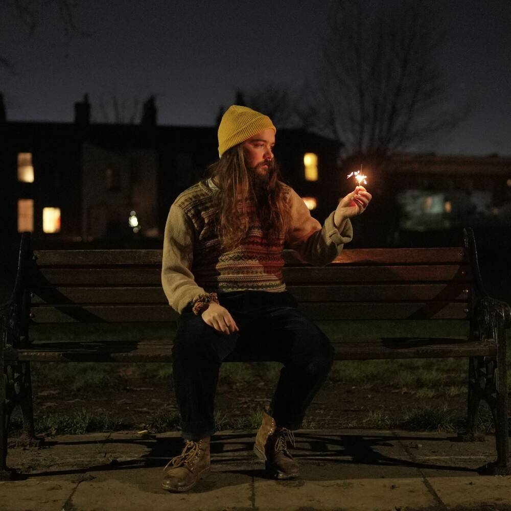 Easymess -- Fireworks and Foxes -- Cover art -- Lead singer Adrien Latgé sitting on a bench at night and holding a sparkler in his hand.