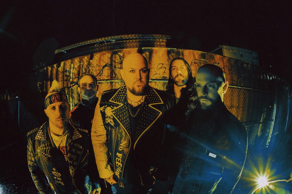 Atreyu band members gather together at night for a group photo wearing black.