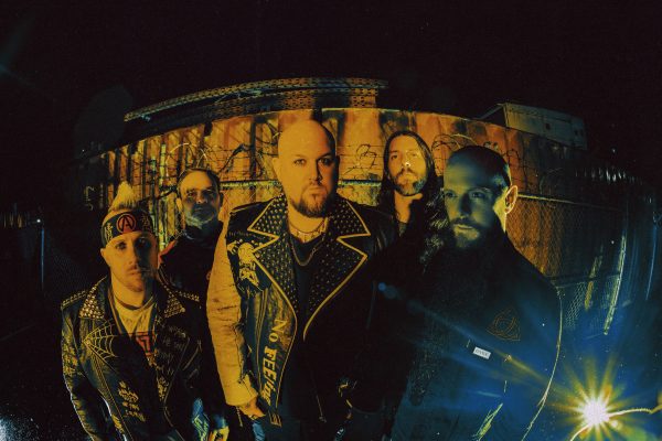 Atreyu band members gather together at night for a group photo wearing black.