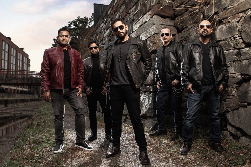 Kronedge poses together in front of a stone wall