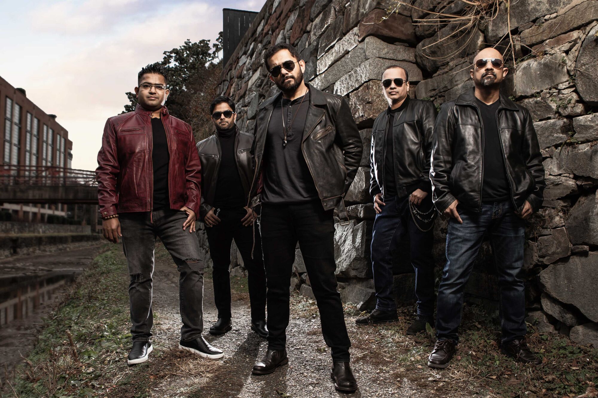 Kronedge poses together in front of a stone wall