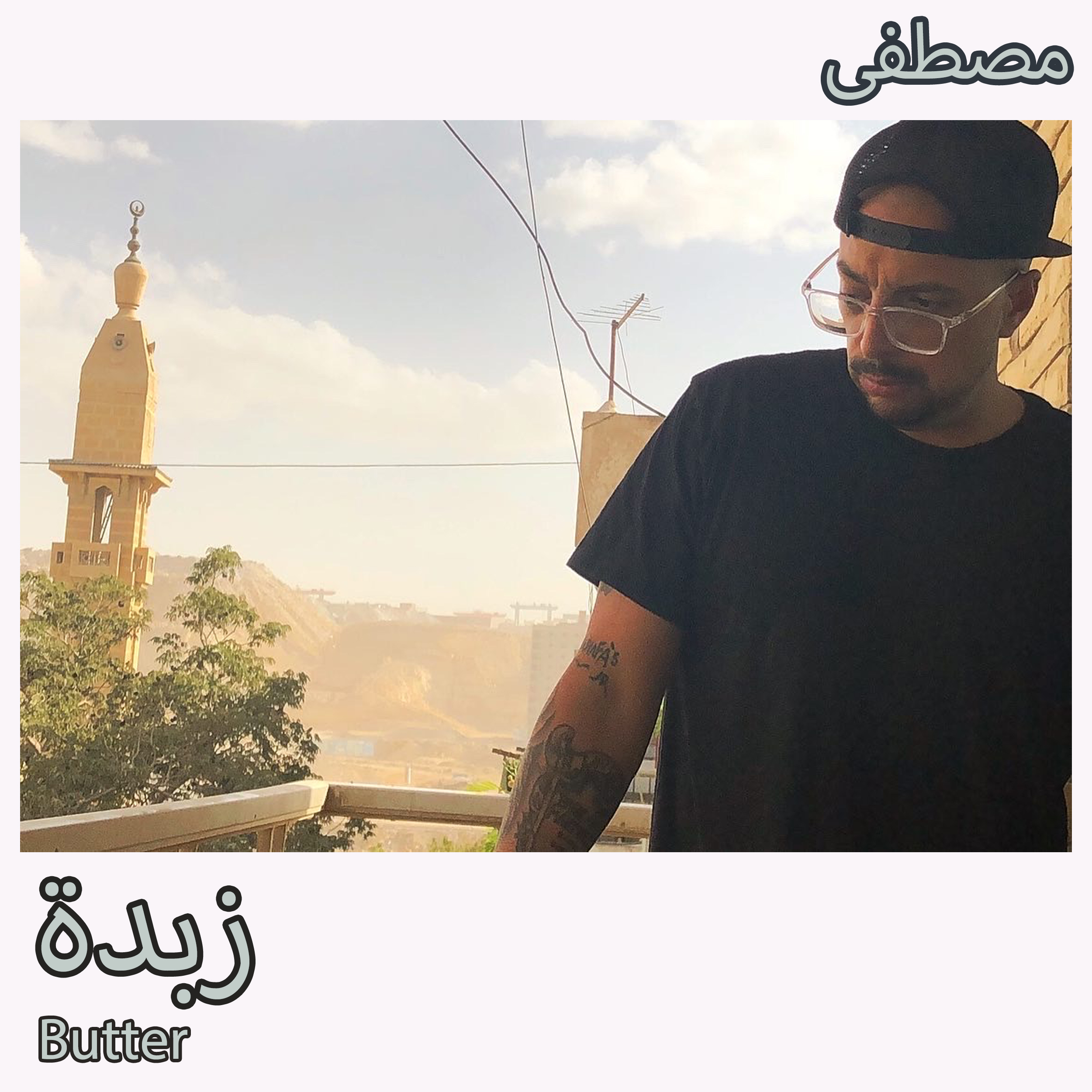 Album art for "Butter" featuring Mostafa wearing a black shirt, glasses, and a black, backwards baseball cap while standing on a deck in Cairo with buildings, trees, and mountains in the background.