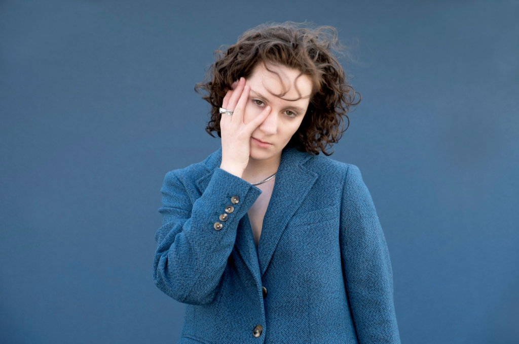 Zola Simone in a blue suit in front of a blue background