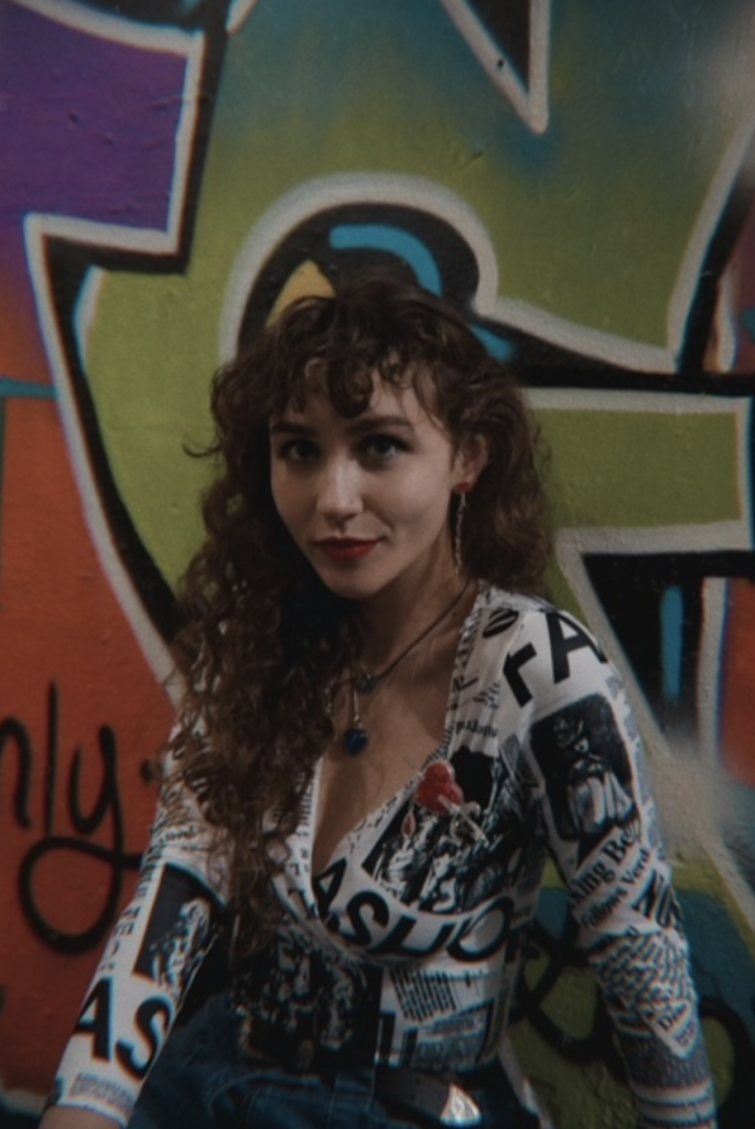 Calista Garcia poses in front of colorful graffiti.