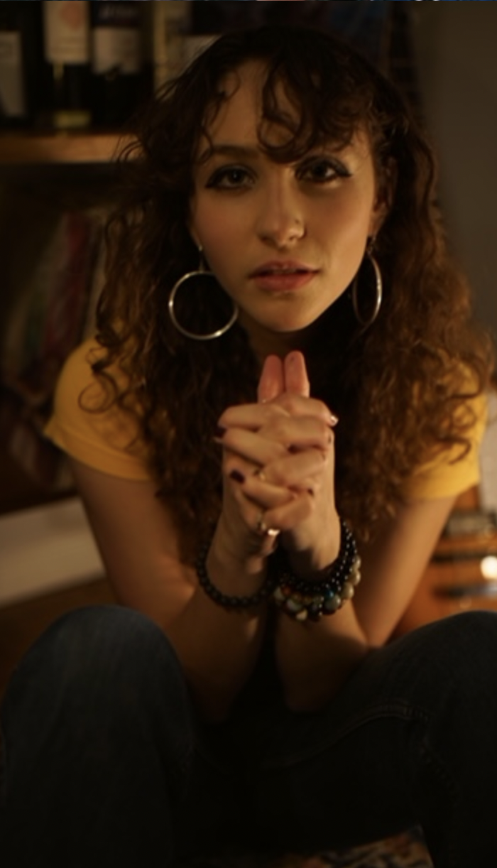 Calista Garcia leans forward with hands folded together.