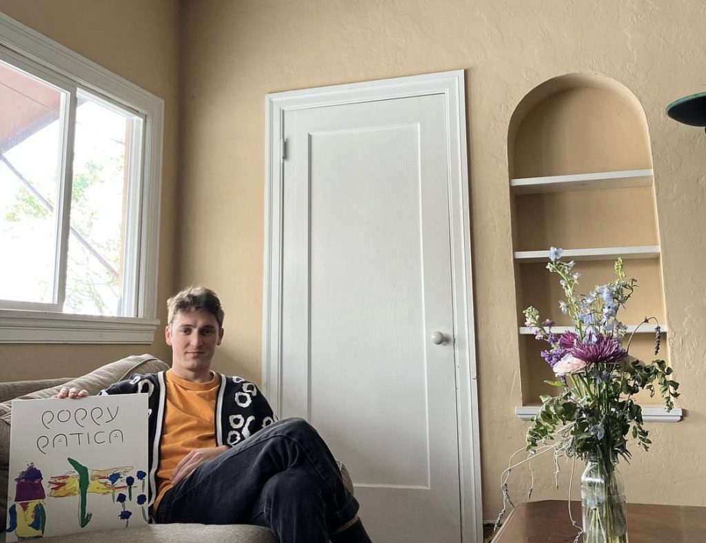 Hartmann with album next to vase of flowers