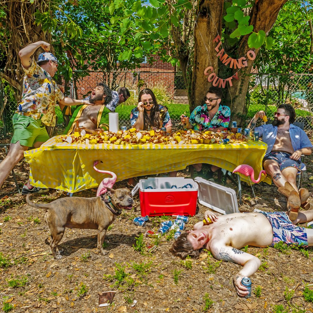 Matthew Lowry - "Flamingo County" album art depicting a "last supper scenerio" with people behind a picnic table covered in corn, an inebriated individual at their feet, and two individuals fighting on the left.