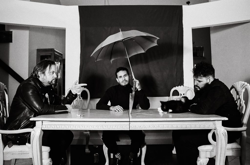 Violet Silhouette pose for a press photo at a dining room table that has a knife in the middle.