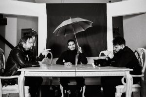 Violet Silhouette pose for a press photo at a dining room table that has a knife in the middle.