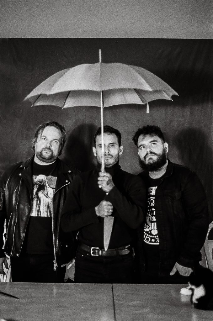Violet Silhouette poses for a black-and-white press photo with the lead singer holding an umbrella and a knife.