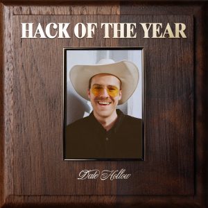 On a plate that imitates an Employee of the Year award, a portrait of Dale Hollow is hung with Hack of The Year written above his portrait in gold lettering, while his name is below it.