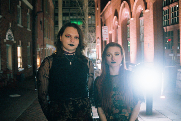 Pennsylvania queer duo Witch Weather pose for a promo photo outside on the street.