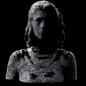 "Vow" cover art of crumbling statue silhouette against a dark black background